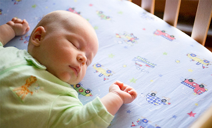 Baby schläft im Gitterbett